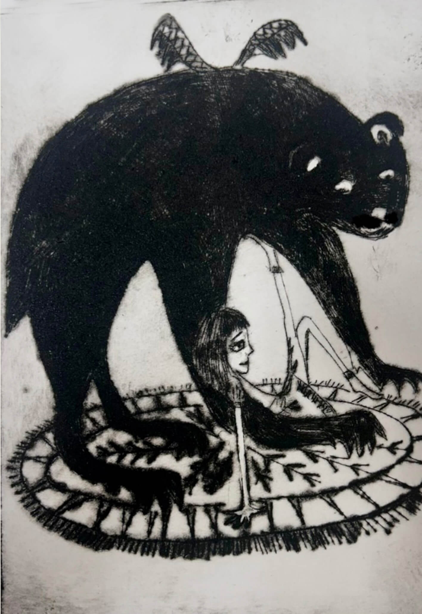A girl sitting on a rug with a black bear.